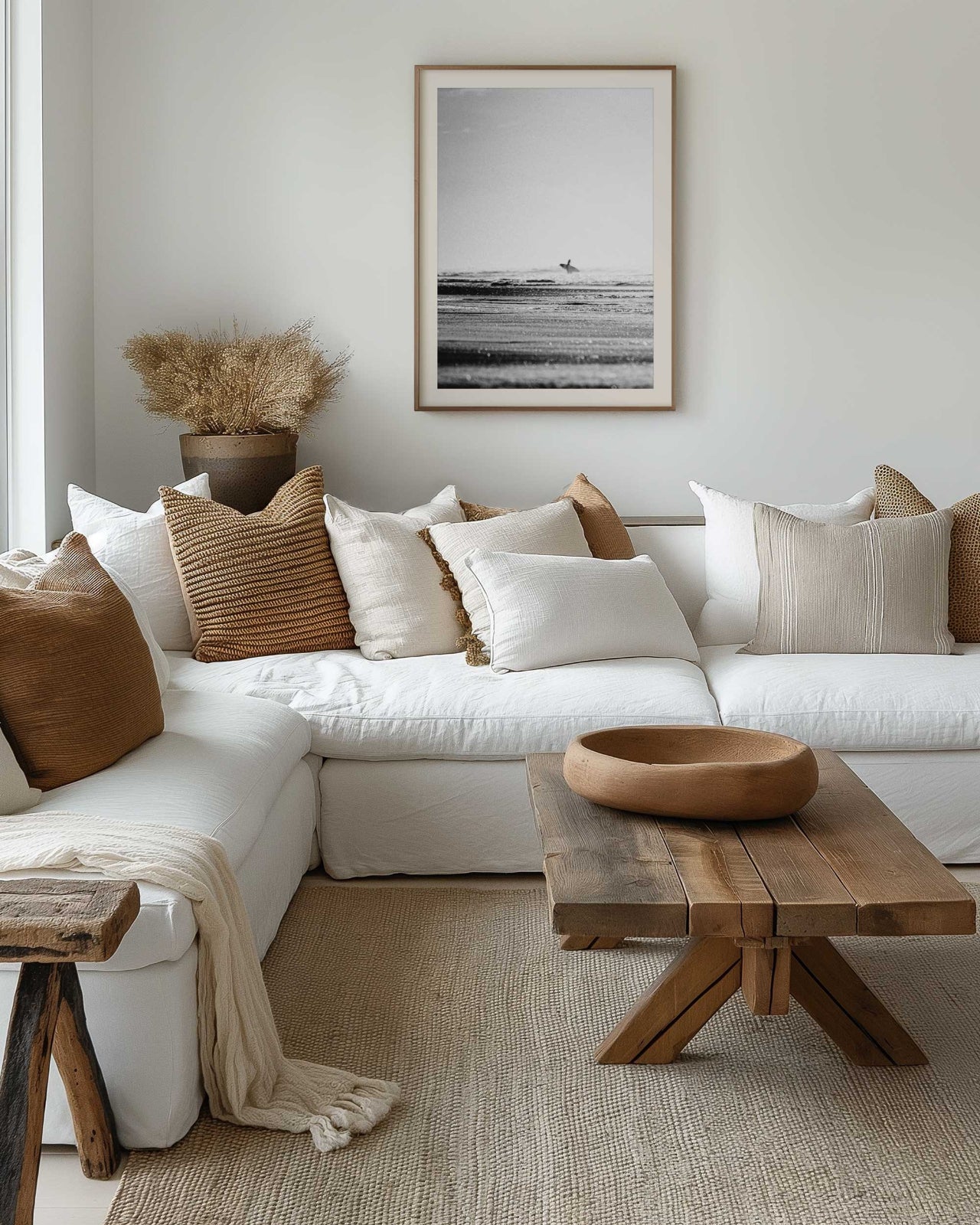 black and white grainy fine art print of surfer walking into surf, taken from the beach. Framed in beautiful neutral lounge room.