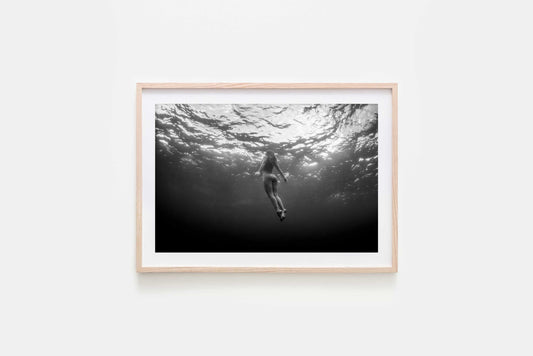 Framed Black and white underwater fine art nude photography captured at Gordon’s Bay, featuring female form in motion