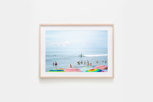 Colourful umbrellas on Sayulita beach, surf inspired ocean fine art photography print framed with natural timber and with a white matte board.