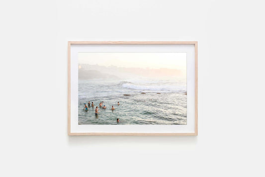 Natural timber framed fine art photography print oBronte Beach scene capturing swimmers in the ocean at sunrise, showcasing the beauty of Bronte Beach.