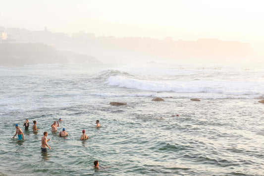 Classic Australian early morning beach ritual, people swimming in the ocean at Bronte Beach during a dreamy summer morning.