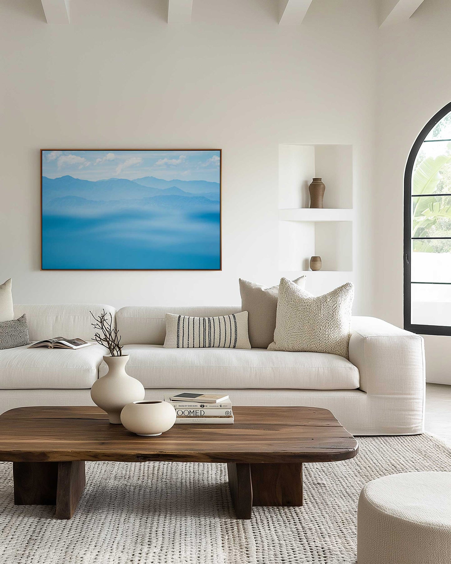 Blue mountain range with a hazy effect and a clear sky image in a natural timber frame displayed in a neutral coloured lounge room