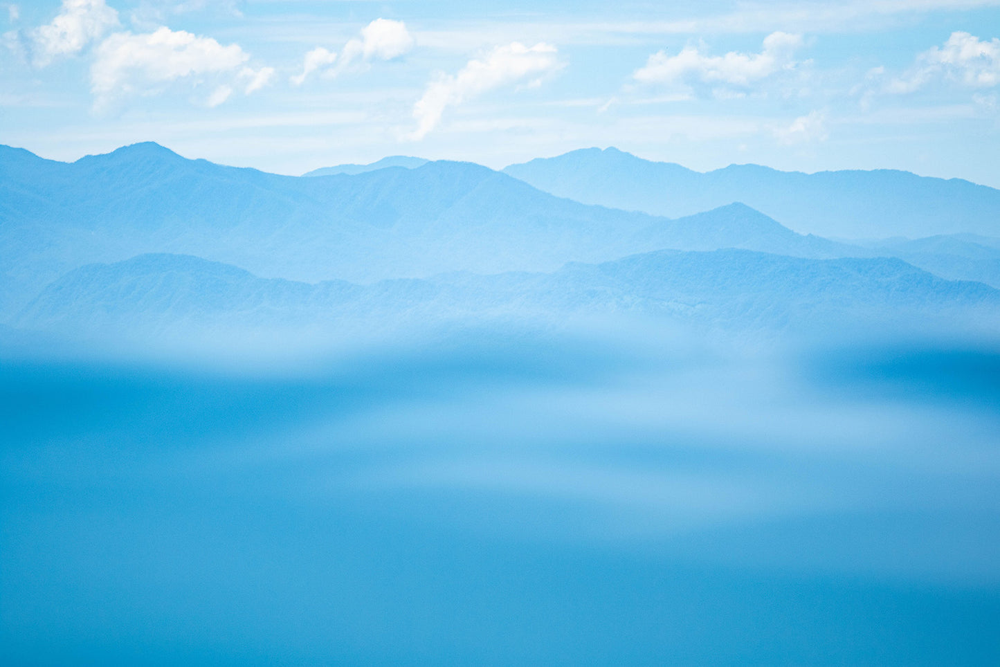 Blue mountain range with a hazy effect and a clear sky.