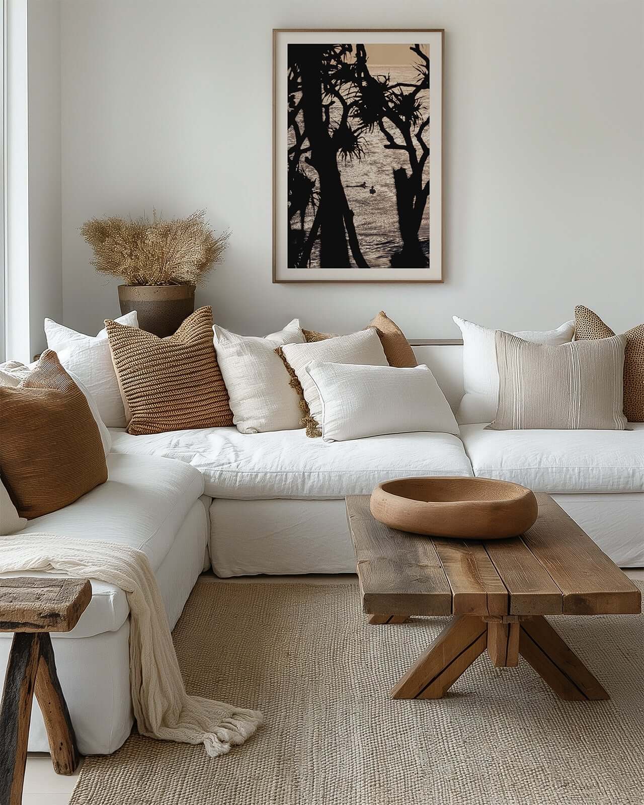 Cabarita Beach pandanus palm fine art print in a timber frame displayed above a white sofa in a cozy neutral living room.