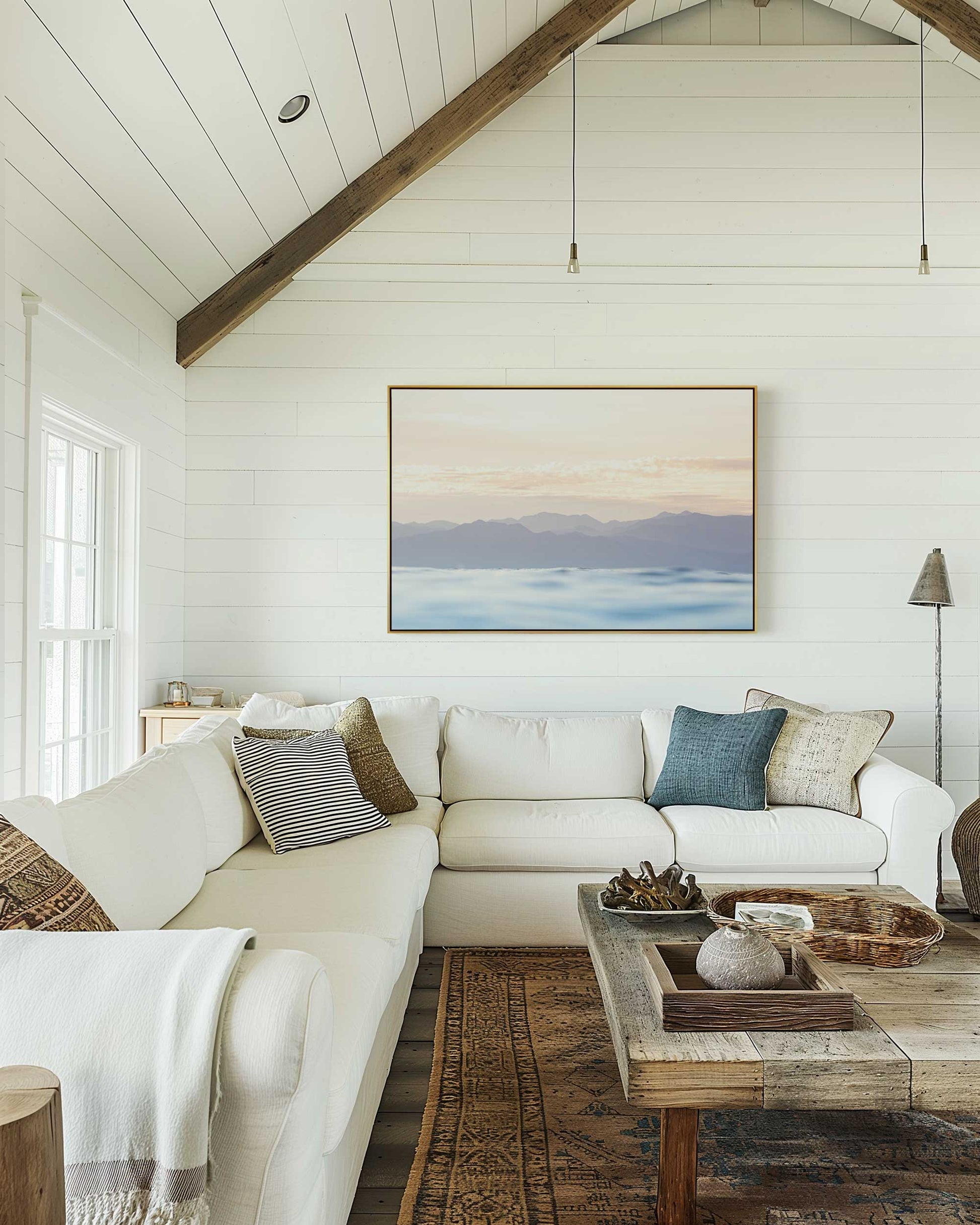 image of a soft pastel sunrise over the mountains and the ocean framed in a beautiful country style lounge room