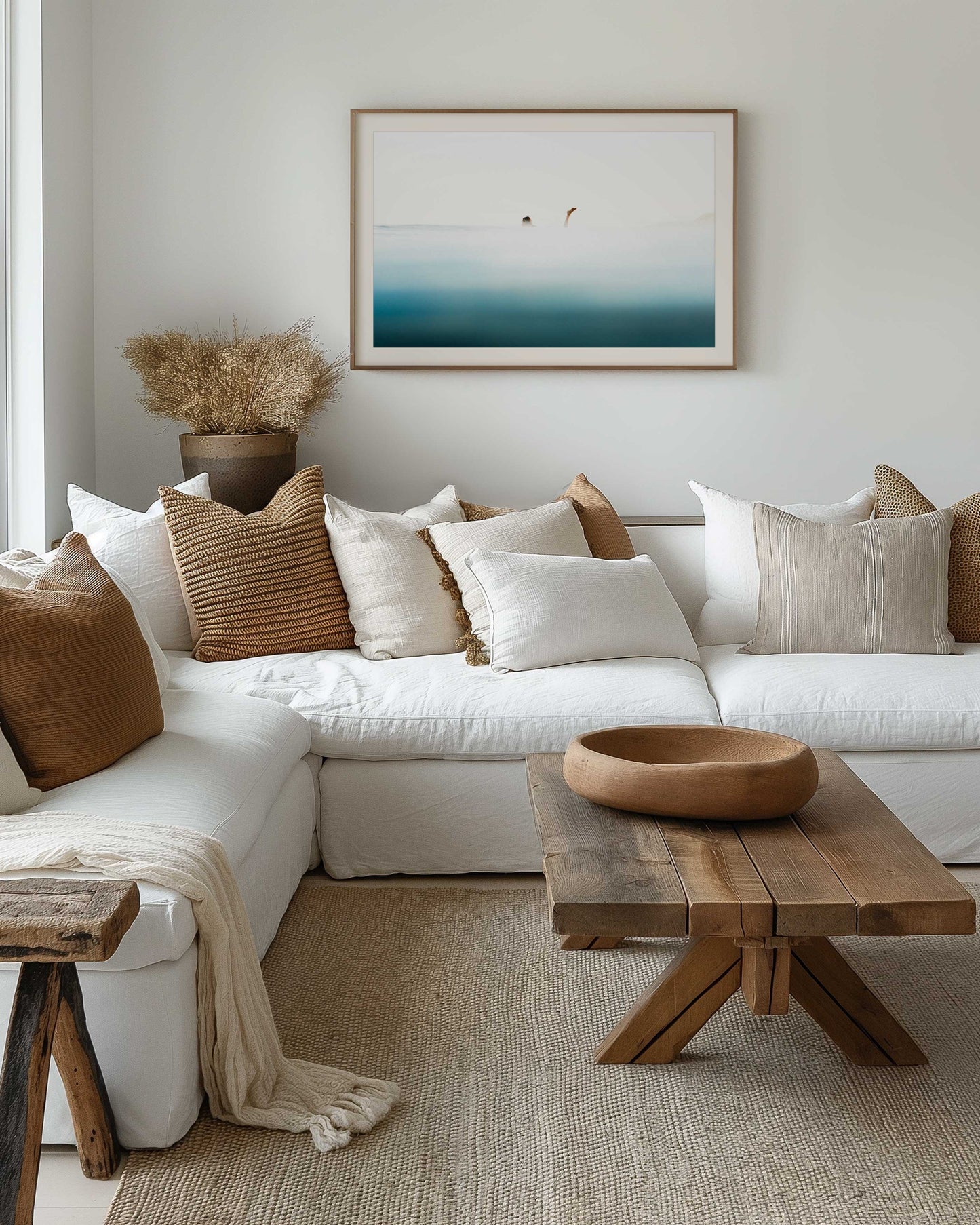 Framed print in rustic lounge room of surfer paddling by blending into the water and sky.