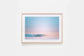 Framed artwork of a wave barrelling with a pastel sky on a white wall